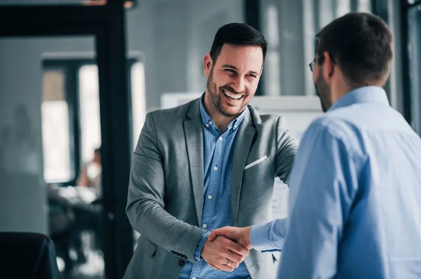 Two executives shaking hands in an office