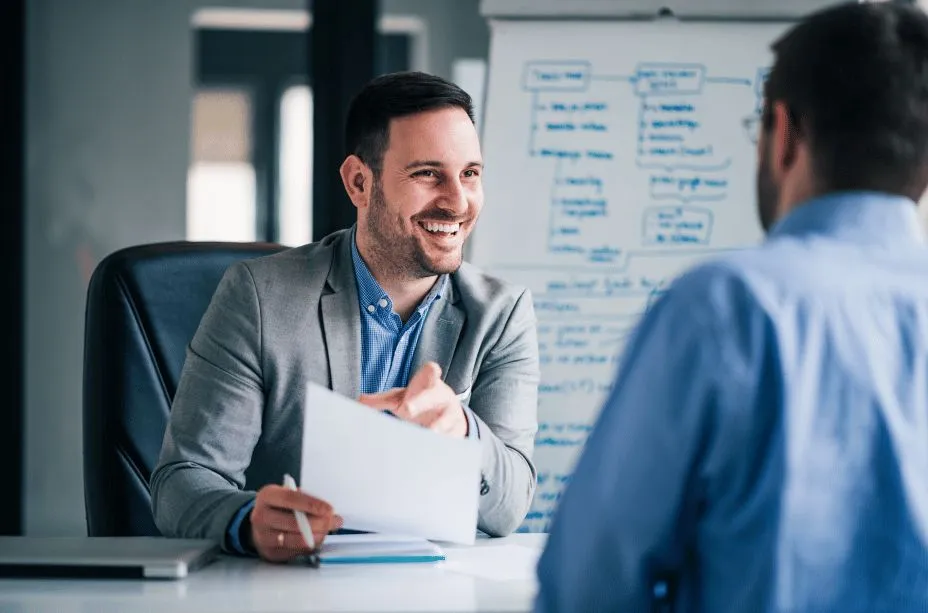 A manager smiling in front of a whiteboard